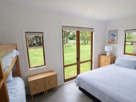 A bedroom with a bunk bed and a double bed at Matapouri Hideaway - Matapouri