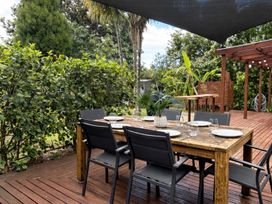 An outdoor dining area with a table and chairs at Matapouri Hideaway - Matapouri