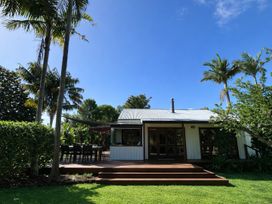 A house with a deck, table and chairs at Matapouri Hideaway - Matapouri