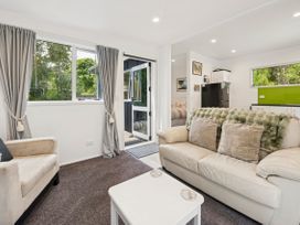 A living room with a sofa and coffee table at Bellbird Cottage - Lake Taupo Bach in Waitahanui
