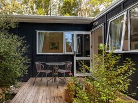A patio area with a table and chairs at Bellbird Cottage - Lake Taupo Bach in Waitahanui