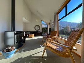 A living room with a fireplace and sofa at Wanaka Tranquility - Wanaka Holiday Home