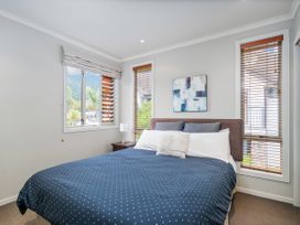 A bedroom with a bed and a lamp at Putt it at Pauanui - Pauanui