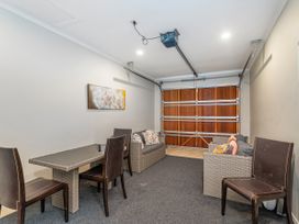 A garage with seating and a table at Putt it at Pauanui - Pauanui