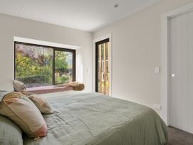 A bedroom with a bed and window at Brow Peak View - Arrowtown Holiday Home