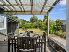An outdoor dining area with a table and chairs at Raisin Town - Marahau Bach in Marahau