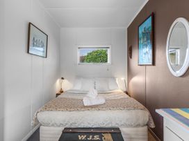 A bedroom with a bed and window at Raisin Town - Marahau Bach Marahau