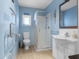 A bathroom with a shower and sink at Raisin Town - Marahau Bach Marahau