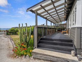 An outdoor deck area with a cactus and flowers at Raisin Town - Marahau Bach in Marahau