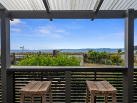 View of outdoor area with wooden chairs and plants at Raisin Town - Marahau Bach in Marahau