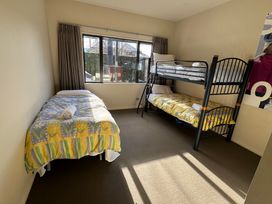 A bedroom with a single bed and a bunk bed at Modern Lake Haven - Wanaka