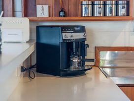 A coffee machine and internet router on a kitchen counter at Heights Haven - Acacia Bay Holiday Home Acacia Bay