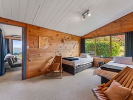 A bedroom with two beds and a wooden chair at Heights Haven - Acacia Bay Holiday Home, Acacia Bay