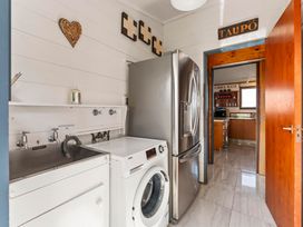 A laundry room with a washing machine and sink at Heights Haven - Acacia Bay