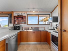 A kitchen with cabinets and appliances including a refrigerator at Heights Haven - Acacia Bay Holiday Home Acacia Bay
