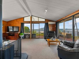 A living room with a television and sofa at Heights Haven - Acacia Bay Holiday Home Acacia Bay