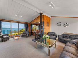 A living room with a fireplace and seating area at Heights Haven - Acacia Bay Holiday Home