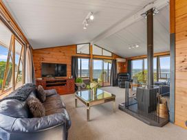 A living room with a sofa and television at Heights Haven - Acacia Bay Holiday Home Acacia Bay