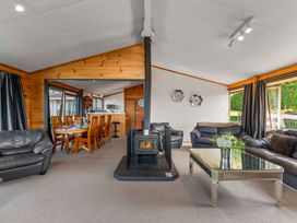 A living room with a sofa and dining table at Heights Haven - Acacia Bay Holiday Home Acacia Bay