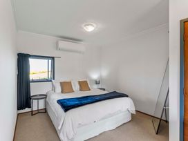 A bedroom with a bed and window at Heights Haven - Acacia Bay Holiday Home Acacia Bay