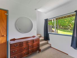 A bedroom with a dresser and mirror at Heights Haven - Acacia Bay Holiday Home Acacia Bay