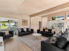 A living room with black sofas and a coffee table at Beachfront Escape - Snells Beach Holiday Home Matakana