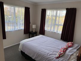 A bedroom with a bed and nightstand at Family at Wharewaka - Wharewaka