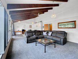 A living room with a sectional sofa and coffee table at Central Spacious Family House - Paihia