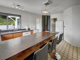 A kitchen with a sink and refrigerator at Central Spacious Family House - Paihia