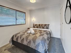 A bedroom with a bed and window at Central Spacious Family House - Paihia