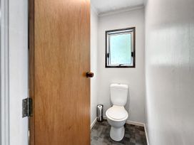 A bathroom with a toilet and a window at Central Spacious Family House - Paihia
