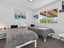 A bedroom with two single beds and a window at Little Pearl of Vista Verano - Mangawhai Village