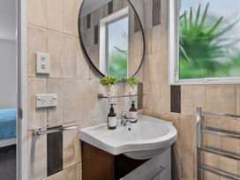 A bathroom with a sink and mirror at Little Pearl of Vista Verano - Mangawhai Village