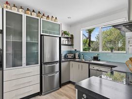 A kitchen with a refrigerator, sink, and countertop at Little Pearl of Vista Verano - Mangawhai Village
