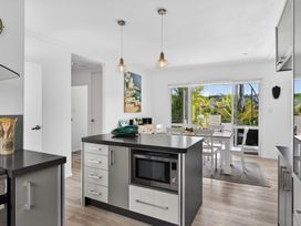 A kitchen with an island and dining area at Little Pearl of Vista Verano - Mangawhai Village