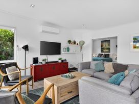 A living room with sofa, coffee table, and television at Little Pearl of Vista Verano - Mangawhai Village