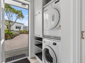 A laundry room with washing machine and dryer at Little Pearl of Vista Verano - Mangawhai Village