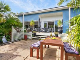 An outdoor dining area with a table and chairs at Little Pearl of Vista Verano - Mangawhai Village