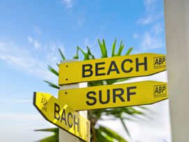A signpost with directions to beach, surf, and bach in Mangawhai Village