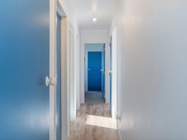 A hallway with blue doors at Nest by the Beach - Cooks Beach
