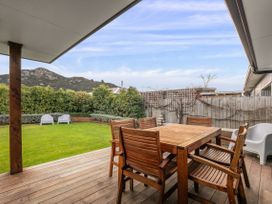 An outdoor area with a wooden table and chairs at Albert Town Wanaka Oasis - Wanaka