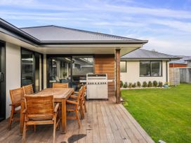 An outdoor area with a table and chairs and a barbecue at Albert Town Wanaka Oasis - Wanaka