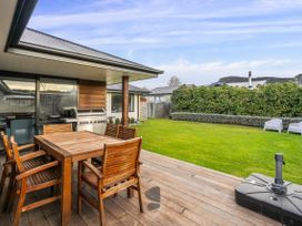 An outdoor area with a wooden table and chairs at Albert Town Wanaka Oasis - Wanaka
