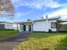A house with a pathway and yard at Wharewaka Bach - Lake Taupo Holiday Home, Wharewaka