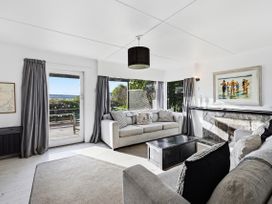 A living room with a sofa and coffee table at Wharewaka Bach - Lake Taupo Holiday Home in Wharewaka