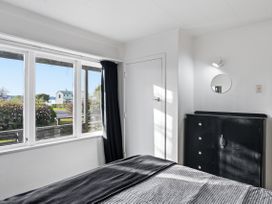 A bedroom with a window and dresser at Wharewaka Bach - Lake Taupo Holiday Home in Wharewaka