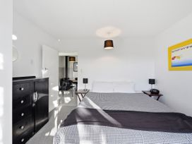 A bedroom with a bed and dresser at Wharewaka Bach - Lake Taupo Holiday Home in Wharewaka