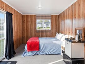 A bedroom with a bed and a window at Wharewaka Bach - Lake Taupo Holiday Home in Wharewaka