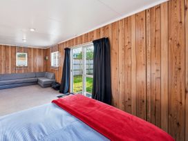 A living room with a sofa and windows at Wharewaka Bach - Lake Taupo Holiday Home in Wharewaka