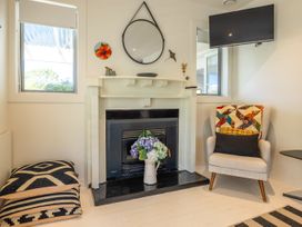 A living room with a fireplace and television at Moa Magic - Oneroa Holiday Home Oneroa